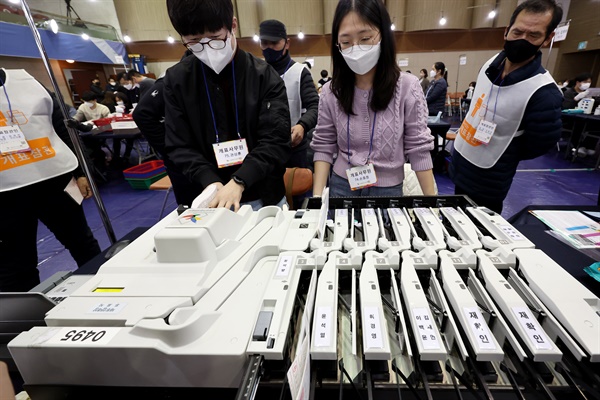 20대 대통령 선거 본 투표일인 9일 오후 서울 중구 중구구민회관에 마련된 개표소에서 투표참관인들이 입회한 가운데 개표 사무원이 투표용지를 분류하고 있다.  