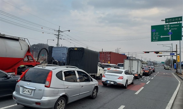 고속도로에서 나온 대형화물차들이 군산으로 가는 국도 21호선으로 가기 위해 좌회전을 기다리고 있다.