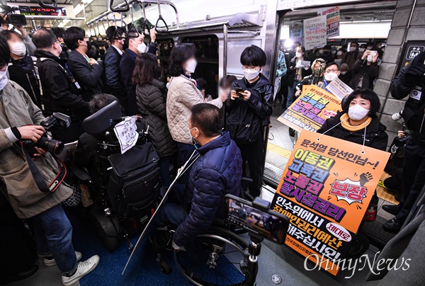 전국장애인차별철폐연대(전장연) 회원들이 3월 28일 서울 종로구 경복궁역 3호선에서 25차 '출근길 지하철 탑니다'를 위해 지하철에 탑승하고 있다.