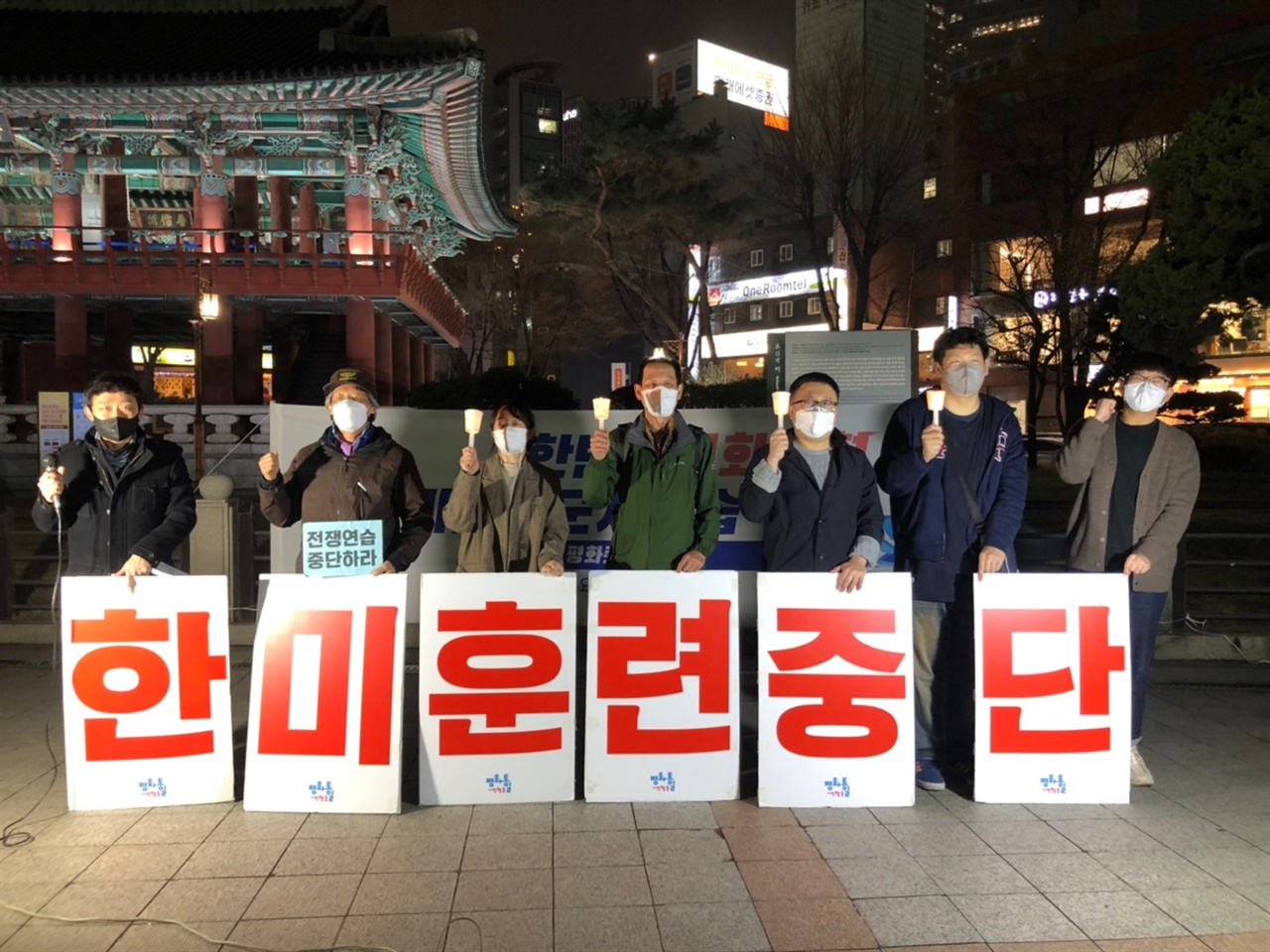 3월 30일 서울 보신각 앞에서 열린 '선제공격, 전쟁훈련! 한미연합군사연습 중단 촉구 수요평화촛불' 참가자들이 ‘'미훈련중단' 피켓을 들고 있다. 