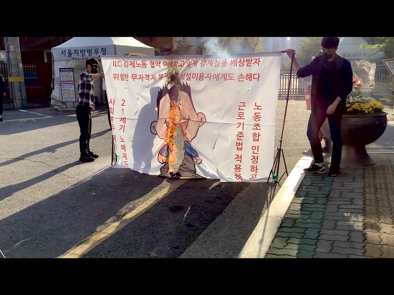 20일, 사회복무요원 노동조합원들이 서울지방병무청 앞에서 굳건이 화형식을 진행하고 있다.