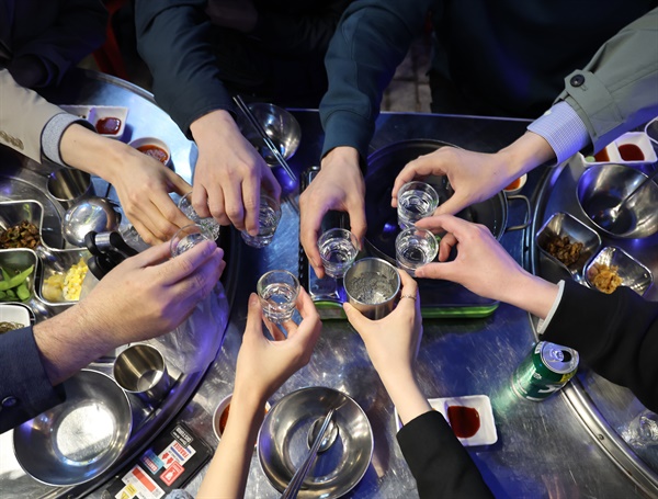 거리두기 전면 해제 첫 날인 지난 18일 저녁 퇴근한 회사원들이 서울 시내 주점에서 건배를 하고 있다.