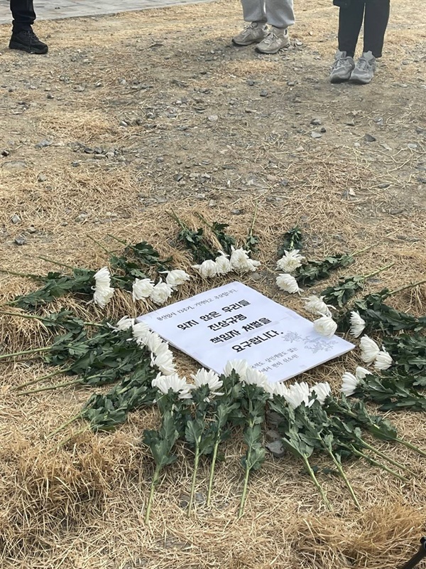 2022년 1월 22일, 다크투어 참여자들이 용산참사 현장에서 꽃을 놓으며 헌화하는 모습.