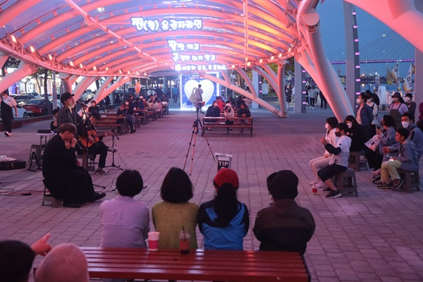 여수해양공원 ‘빛 광장’에서 3인조 어쿠스틱 밴드 OTB  공연을 보는 관객들

