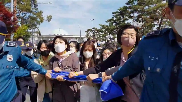 여성가족부 폐지 저지 공동행동이 대통령 취임식이 있던 국회 앞에서 현수막을 펴며 구호를 외치자 경찰들이 저지하고 있다. (영상 캡처)