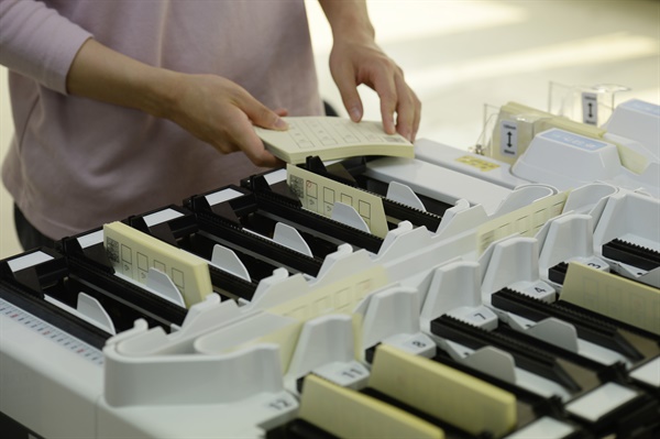 2022년 6.1 지방선거를 보름 앞둔 2022년 5월 17일 오후 서울 송파구선거관리위원회에서 개표에 참여할 관계자들이 자동 투표용지 분류기 사용 연습을 하고 있다.