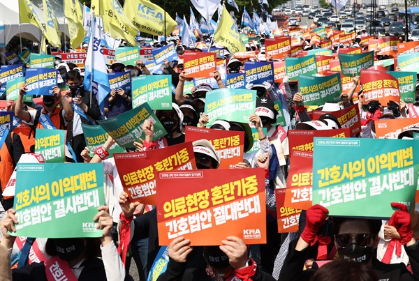 22일 오후 서울 여의대로에서 열린 '간호법 제정 저지를 위한 공동 궐기대회’에서 대한의사협회 및 대한간호조무사협회원들이 관련 피켓을 들고 있다.