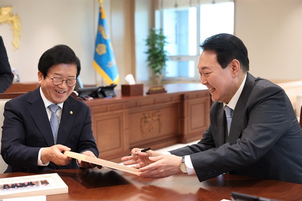  윤석열 대통령이 24일 용산 대통령실 청사 집무실에서 국회의장단을 접견하며 박병석 국회의장에게 바이든 미국 대통령과 함께 찍은 사진 액자를 선물하고 있다.