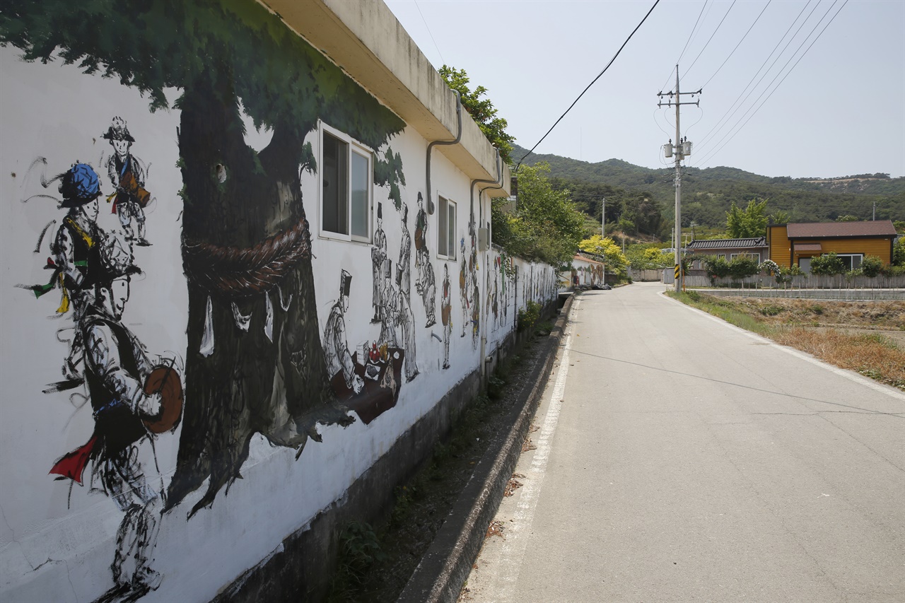 용암마을의 담장 벽화. 마을의 당산제와 줄다리기 이야기를 담고 있다.