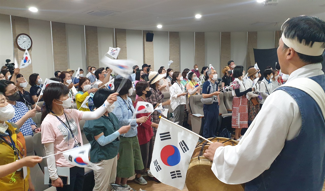 '남도 민주평화길' 연수 참가자들이 '친일, 항일 음악극'을 보며 출연자들과 함께 태극기를 흔들고 있다. 지난 5월 28일이다.