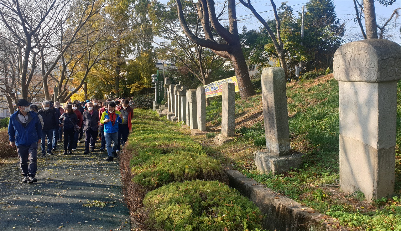 '남도 민주평화길' 연수 참가자들이 김남철 회장의 설명을 들으며 함평공원 비석 거리를 걷고 있다. 지난해 11월이다.