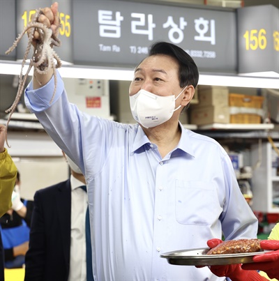 윤석열 대통령이 5월 31일 부산 중구 자갈치시장을 찾아 산낙지를 들어보이고 있다. 