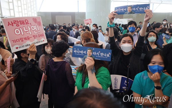  이낙연 더불어민주당 전 대표가 7일 오전 인천국제공항 제2여객터미널에서 미국으로 출국하자, 환송 나온 지지자들이 손피켓을 들어보이며 배웅하고 있다.