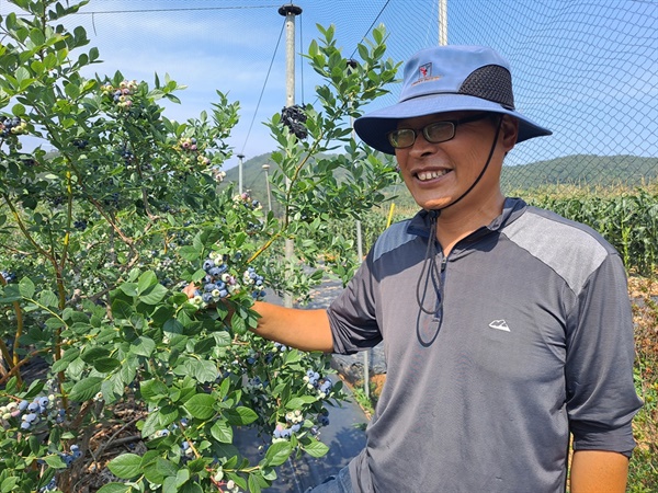 ‘여수 우리베리팜’ 블루베리 농장 신기수 대표가 블루베리 열매를 자랑하며 환하게 웃고 있다.