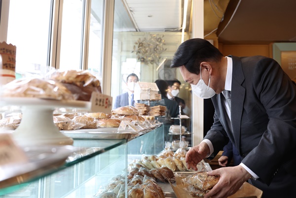 윤석열 대통령이 19일 서울 용산 대통령실 청사 인근 국숫집에서 점심 식사를 마친 뒤 제과점에서 빵을 구매하고 있다. 