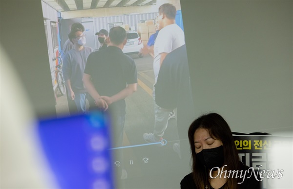 CJ대한통운 택배노동자 고 전민씨 부인 박혜진씨와 박씨의 아버지이자 고인의 장인인 박용선씨가 근무기록을 요구하기 위해 전씨가 일한 화물터미널에 방문한 당시의 영상을 기자회견에서 보여주고 있다. 