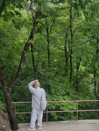 갓바위 계단 길을 오르던 한 스님이 휴식을 취하고 있다.