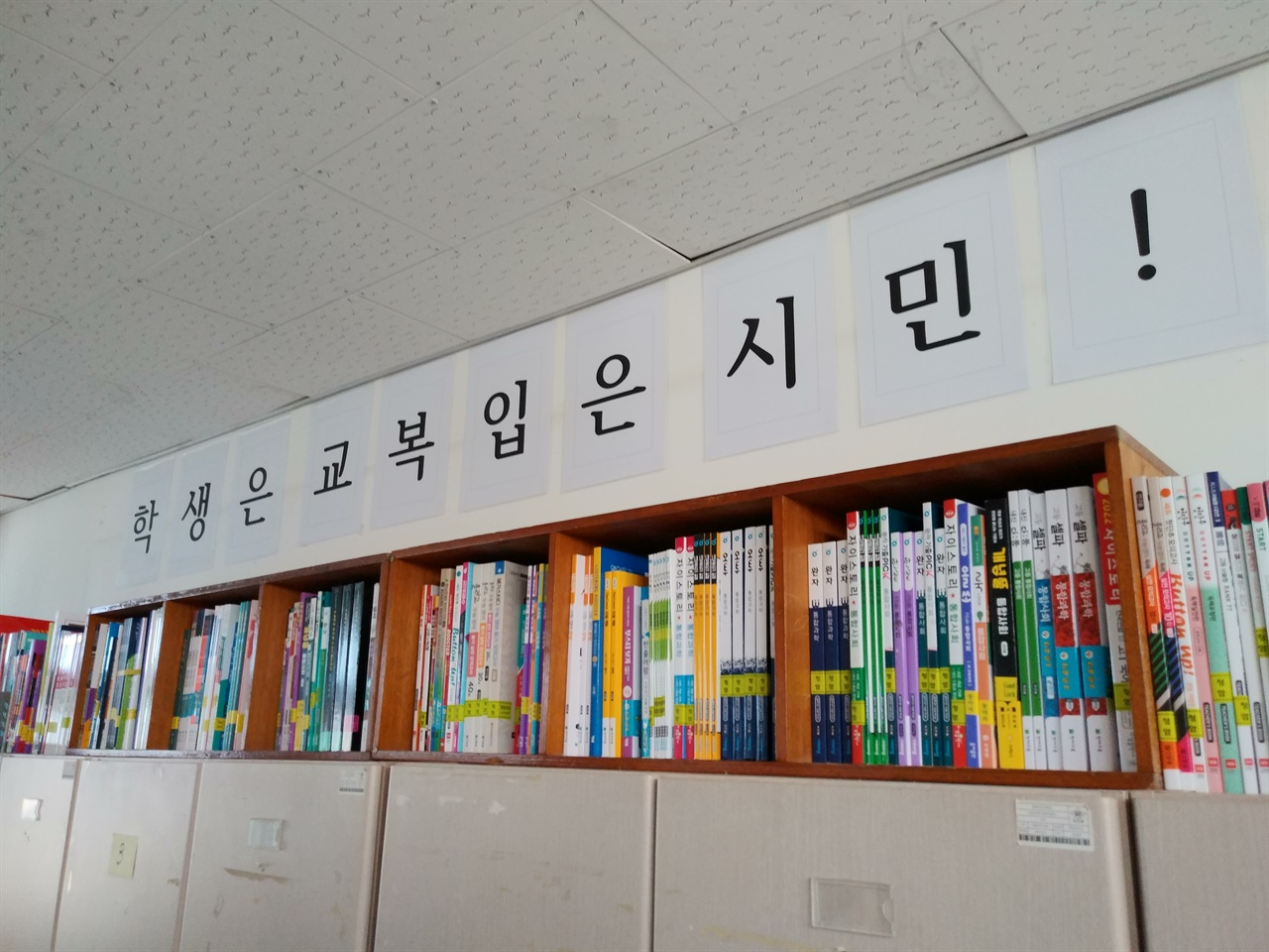 학년 교무실 벽면에 붙여놓은 글귀 아래로 수험서가 가득 꽂혀있다. 한 아이가 '학생은 문제집 푸는 기계'라고 바꿔 불러야 한다며 조롱하듯 말했다.