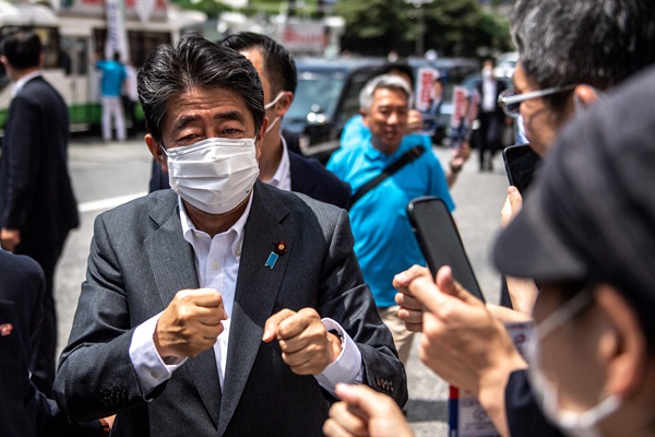 지난 6월 22일 아베 신조(安倍晋三) 전 일본 총리가 일본 도쿄에서 열리는 참의원 선거를 앞두고 자민당 아사히 겐타로 의원 선거유세에 동참하면서 지지자들과 주먹인사를 하고 있다. 