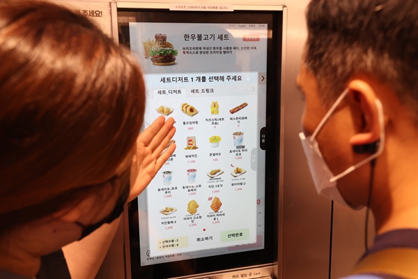 시각장애인들이 12일 서울의 한 패스트푸드점을 찾아 무인주문기(키오스크)에서 실제 주문을 해보는 '내돈내산 권리찾기 캠페인'을 하고 있다. 사진은 한 참가자가 직원의 도움으로 메뉴를 고르는 모습.