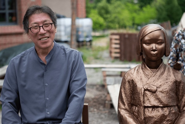 지난 2022년 독일 카셀대에 설치한 소녀상 곁에 앉은 김운성 작가. 김 작가와 김서경 작가 부부는 부산 일본영사관 앞 평화의 소녀상도 조각했다.