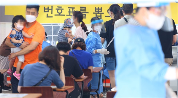 지난 18일 서울 강남구보건소에 설치된 임시선별진료소를 찾은 시민들이 검사 순서를 기다리고 있다.