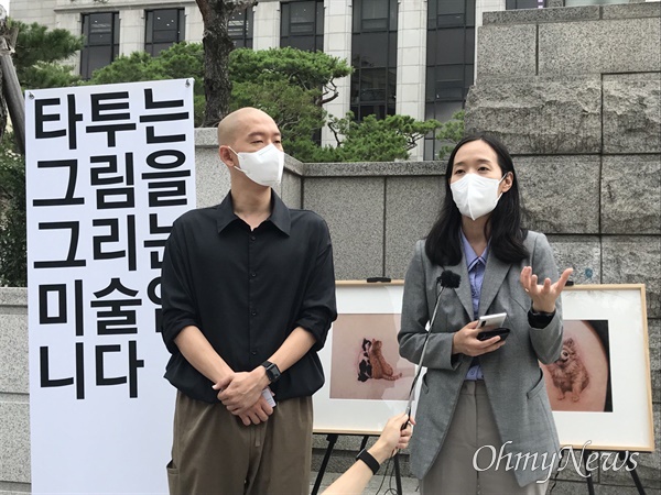 김도윤 타투유니온지회장(왼쪽)과 곽예람 변호사가 21일 오후 헌법재판소 선고가 끝난 후 정문 앞에서 약식 기자회견을 열고 발언하고 있다.