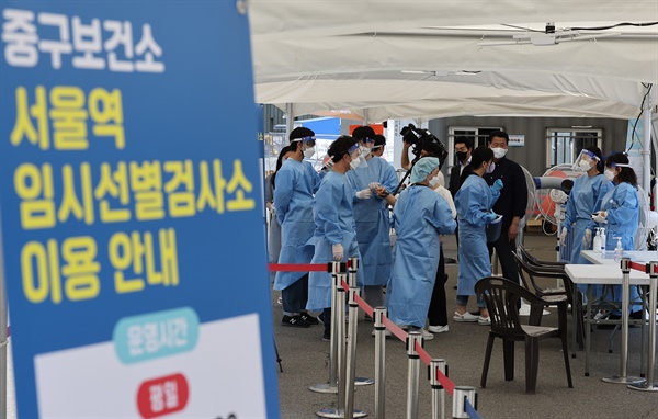  코로나19 재확산으로 지난 25일 오후 다시 문을 연 서울 중구 서울역 임시선별검사소에서 의료진이 검사를 준비하고 있다.