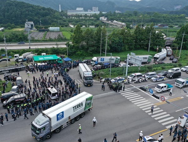 4일 강원 홍천군 하이트진로 강원공장 입구에서 민주노총 공공운수노조 화물연대가 사흘째 농성을 벌이는 가운데 주류운반 차량이 경찰의 호위를 받으며 공장과 집회 장소를 빠져나가고 있다. 