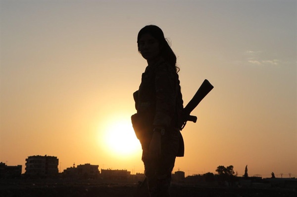 YPJ 여전사가 석양을 바라보고 서 있다. Biji Rojava