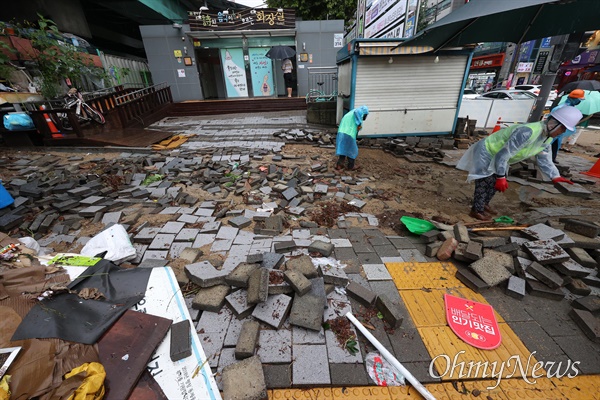 전날 저녁 내린 폭우로 인해 9일 오전 서울 관악구 신대방역 부근 인도가 훼손되어 있다.