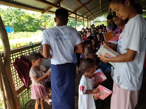 2022년 8월5일 미얀마 중부 모처의 피란민 캠프 내 학교에서 자원봉사자들이 아이들에 교보재를 나눠주고 있다.