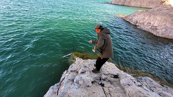 몽골 가이드 저리거씨가 호수에서 고기를 잡아 올리고 있다
