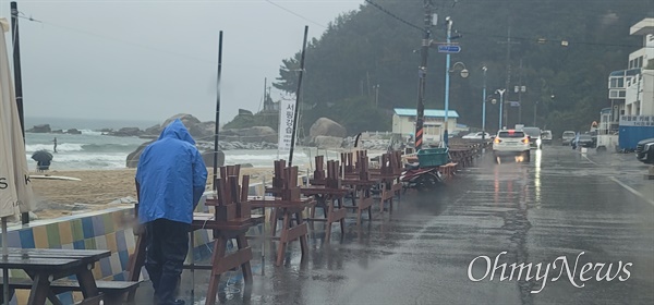 태풍 힌남노가 북상하는 가운데 5일 오전 강원도 양양군에서 한 주민이 테이블을 정리하고 있다.