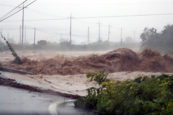 태풍 '힌남노'로 많은 비가 내리면서 6일 오전 경북 포항시 남구 장기면 일대 도로가 하천 범람으로 물에 잠기며 거대한 물보라를 일으키고 있다. 