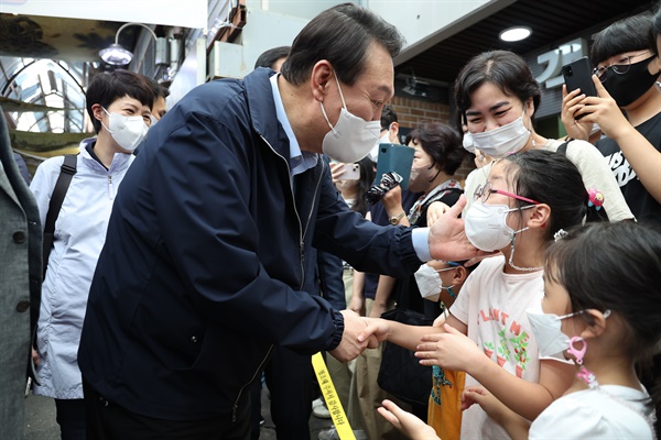 윤석열 대통령이 추석 연휴 첫날인 9일 서울 종로구 통인시장을 찾아 어린이와 인사를 나누고 있다.