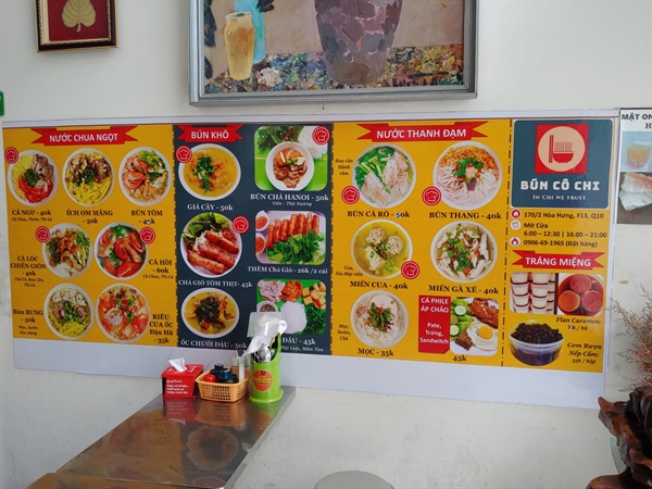 벽에 그림들과 시각적으로 멋진 메뉴판이 걸린 한 식당 모습.