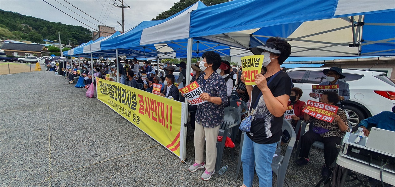  13일 충남 서천군청 민원인 주차장에서 열린 서천읍 두왕리 건설폐기물 중간처리사업 반대 집회에서 주민들이 반대입장을 담은 피켓을 들고 구호를 외치고 있다.