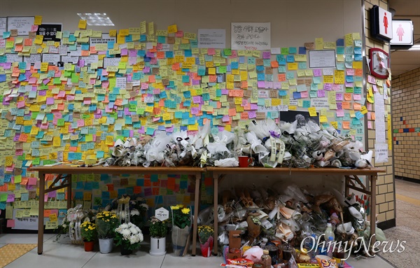 지난해 9월 20일, 서울 지하철 2호선 신당역 여성화장실 입구에 스토킹 살인사건으로 희생된 여성역무원을 추모하는 시민들이 가져다 놓은 국화꽃과 메모가 빼곡하게 붙어 있다.