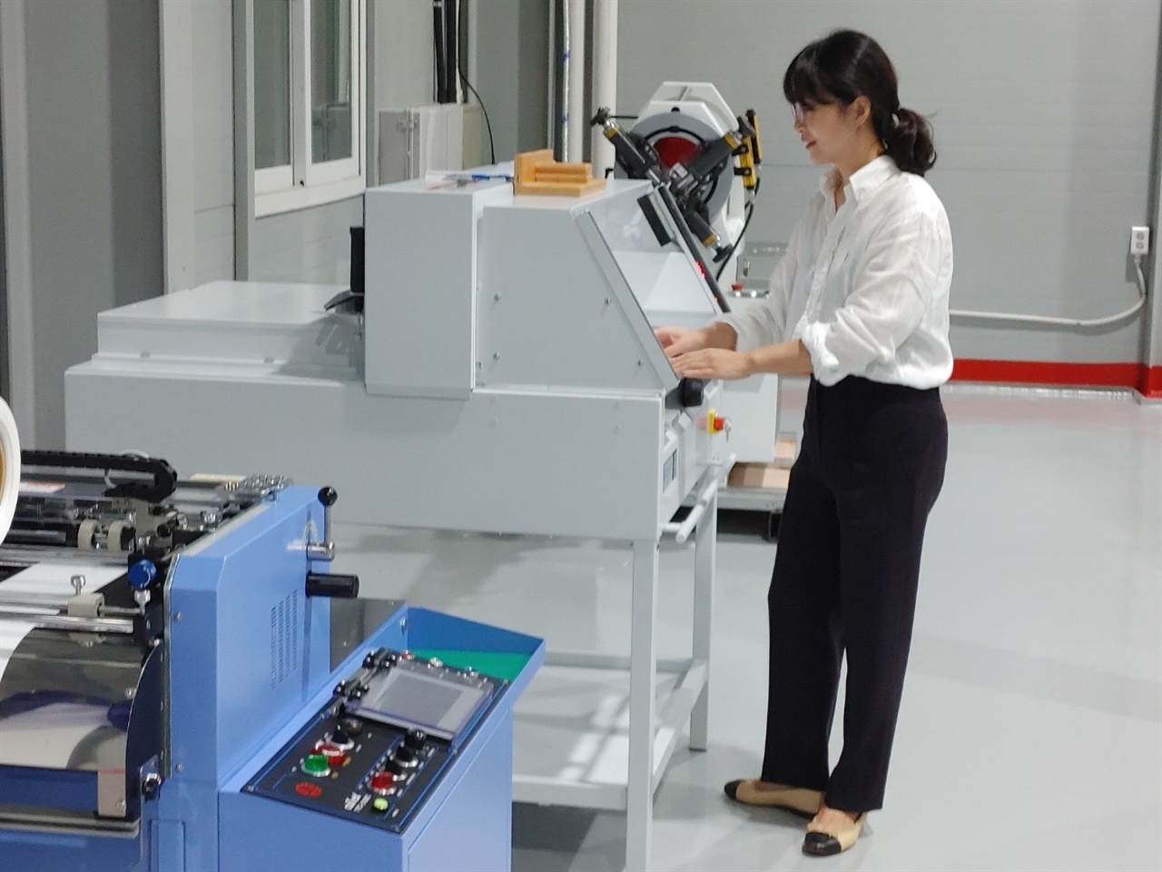 테이프리 대표 김선정씨가 하트테이프 라벨지인 속지를 생산하는 기계를 점검하고 있는 모습

