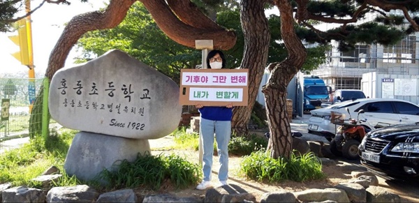 예산홍성환경운동연합 회원이 홍동초 앞에서 '기후위기' 캠페인을  진행했다. 