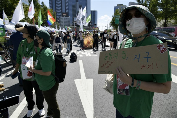 녹색당의 한 당원이 심각한 주제를 적은 손피캣을 든 체 우아한 퍼포먼스를 벌이고 있다. 