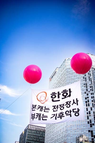 지난 9월 24일, 서울 한화빌딩에 "한화, 본캐는 전쟁장사, 부캐는 기후악당"이라고 쓰인 애드벌룬이 띄워졌다. 기후정의행진에 참여한 3만 5천명의 시민들은 이 앞을 지나며 "생명파괴, 기후파괴 방위산업을 끝장내자"라고 구호를 외쳤다. 