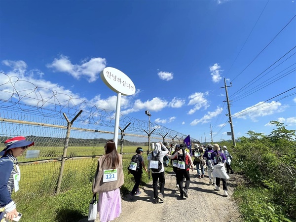 24일 ′2022 경기도 DMZ 여성평화걷기′ 행사에 참가한 성원들이 철조망을 곁에 두고 생태탐방로를 걷는 장면