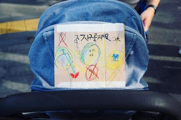 924 기후정의행진. 유모차를 타고 참여한 아이의 유모차에 '지구를 지켜요' 피켓이 올려져 있다. 