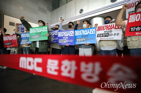 9월 28일 서울 마포구 MBC 본사를 항의 방문한 국민의힘 의원들 모습 뒤로 전국언론노동조합 MBC본부 조합원들이 손피켓을 들고 구호를 외치고 있다.