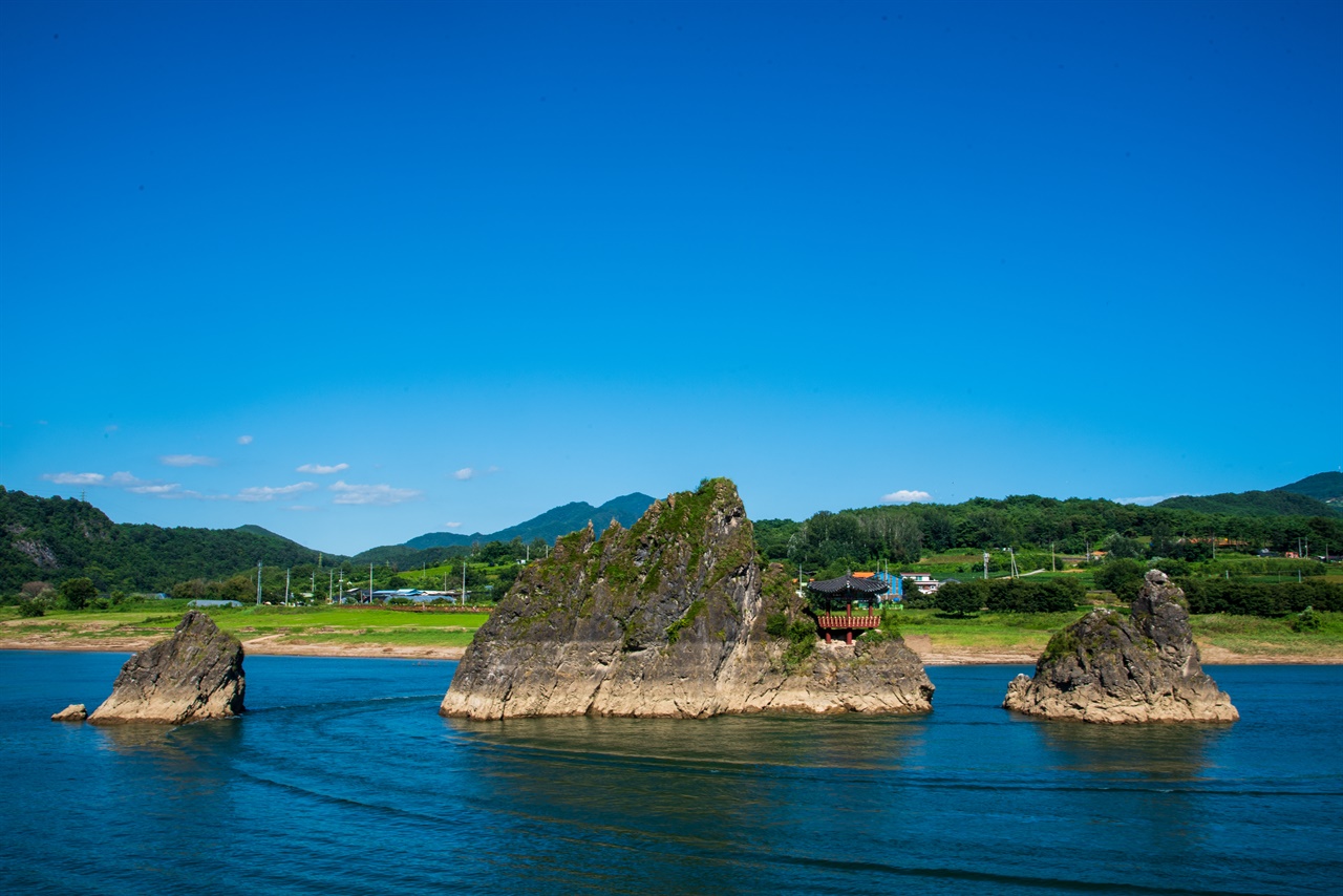 명승 제44호 도담삼봉, 가운데에 있는 큰 봉우리는 장군봉, 왼쪽이 처봉, 오른쪽이 첩봉이다. 장군이 부인을 등지고 임신한 첩을 바라보는 형상과 같아서 이렇게 이름지었다고 한다. 장군봉에 있는 정자 이름은 삼도정인데, 원래 조선 후기 때 세워졌다가 홍수로 유실되어 1976년 철근콘크리트 정자로 재건한 것이다.
