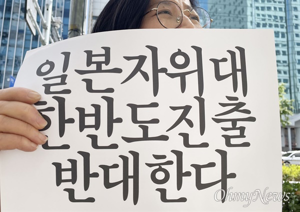 부산겨레하나가 주최하는 부산수요시위가 12일 부산 일본영사관 평화의소녀상 앞에서 열리고 있다. 구호를 외치는 참가자.
