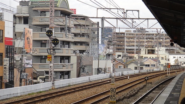 마을 사이를 가로질러 달리는 일본 오사카 지역의 지상 전철