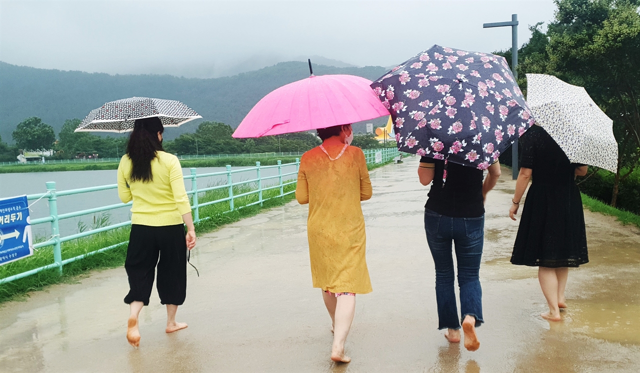 비 오는 날 대구 수성못 산책길 맨발걷기 하는 시민들 모습.
